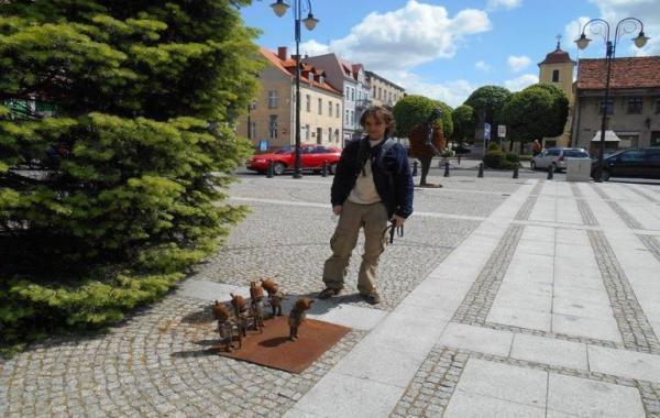 człowiek stoi przy metalowych ludzikach